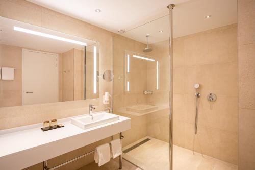 a bathroom with a sink and a shower at Van der Valk Hotel Schiphol in Hoofddorp