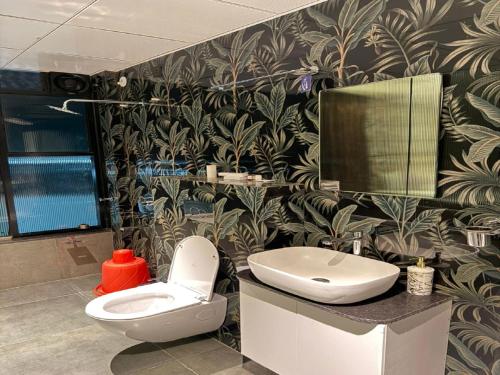 a bathroom with a toilet and a sink and a mirror at Hotel SK Chakan Pune in Dehu