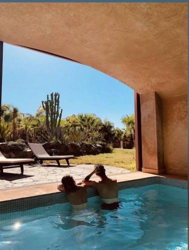 two women in a swimming pool in a house at Villa Malika Private Luxury Villa Marrakech in Tameslouht