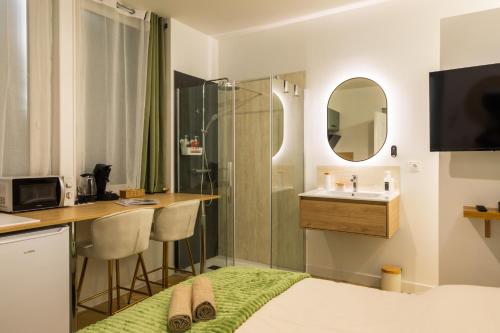 a hotel room with a bed and a sink at Le Sauge - Studio climatisé - Cocon rénové in Agen