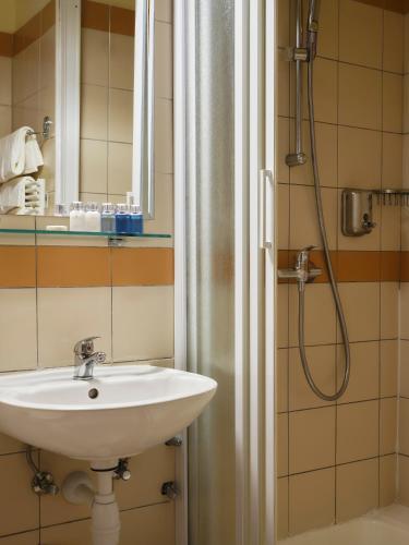 a bathroom with a sink and a shower at Amadria Park Beach Hotel Niko in Šibenik
