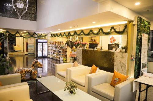 a store lobby with white chairs and a counter at Chaba Inn Srinakarin in Bangna