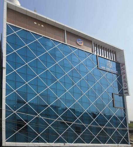 a large glass building with a sign on it at Sree Guru Sannidhi in Jāmb