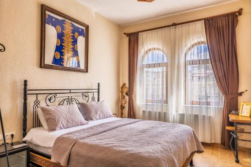 a bedroom with a bed and two windows at Ayaz Stone House in Göreme