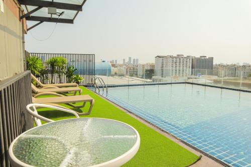 a balcony with a table and chairs next to a swimming pool at Chaba Inn Srinakarin in Bangna