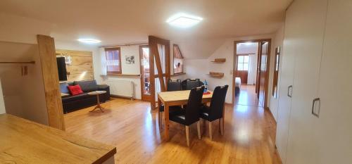 a dining room and living room with a table and chairs at Gästehaus Holzer Kreuz - Ferienwohnung "Mohn" in Fröhnd