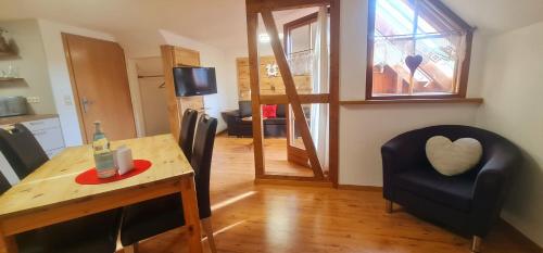 a room with a table and a chair with a heart pillow at Gästehaus Holzer Kreuz - Ferienwohnung "Mohn" in Fröhnd
