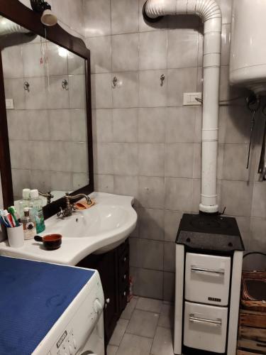 a bathroom with a sink and a stove at The Golden Eagle - Champdepraz in Champdepraz