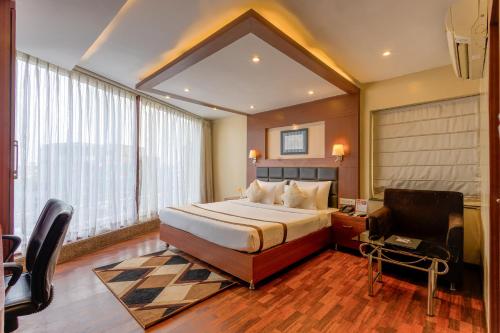 a bedroom with a bed and a desk and a chair at Hotel Sawood International in Kolkata