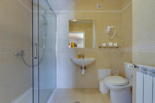 a bathroom with a shower and a toilet and a sink at Nice double bedroom in beautiful Quinta - QR06 in Lagos