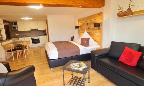 a hotel room with a bed and a couch and a table at Gästehaus Holzer Kreuz - Ferienwohnung "Narzisse" in Fröhnd