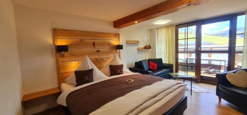 a bedroom with a large bed and two chairs at Gästehaus Holzer Kreuz - Ferienwohnung "Narzisse" in Fröhnd