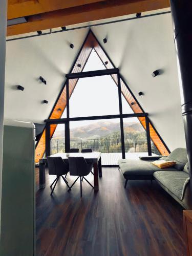 a living room with a table and a large window at Villa Perush in Vuzenica