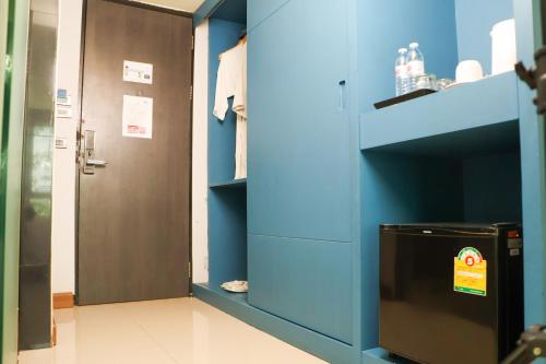 a bathroom with a blue wall and a door at Chaba Inn Srinakarin in Bangna