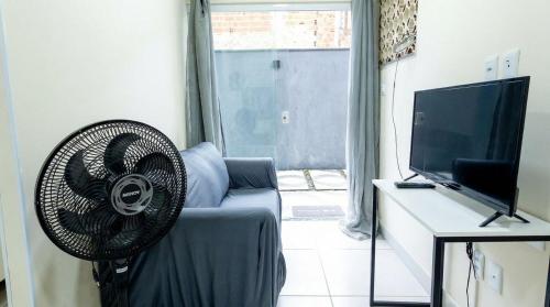 a living room with a fan and a television at Studio Completo c Wifi perto do Centro de Itabuna in Itabuna