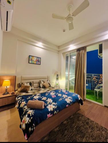 a bedroom with a bed and a large window at Kervan stays in Greater Noida