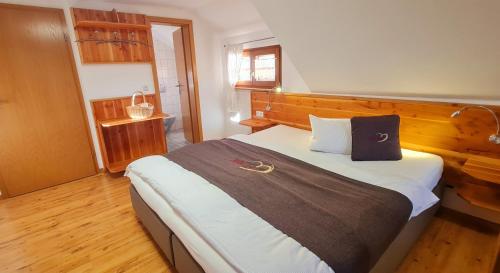 a bedroom with a large bed with a wooden headboard at Gästehaus Holzer Kreuz- Gästezimmer Margerite für 2 Personen inkl Landfrühstück in Fröhnd