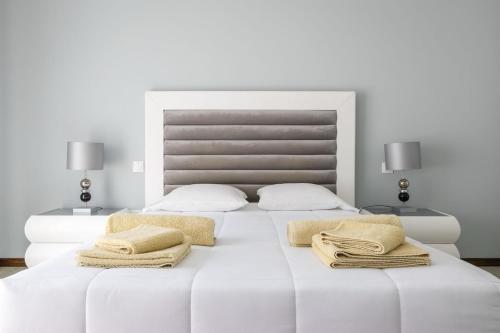 a white bedroom with two beds and two lamps at The Spot - ilha de São Miguel (Povoação) Açores in Povoação