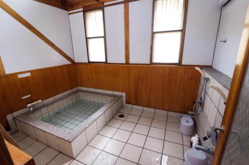 a bathroom with a large tub and a toilet at Guest House Eleven Village Fukiya in Fukiya