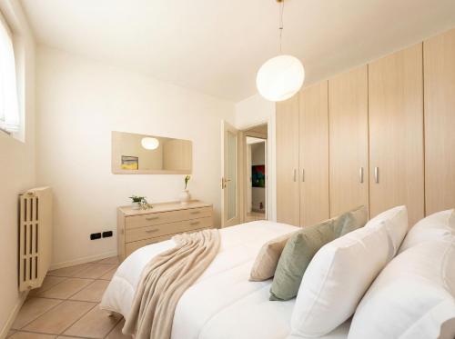 ein Schlafzimmer mit einem weißen Bett und einer Kommode in der Unterkunft Central Duplex in Iseo - 2 Bedrooms - Private Parking & WiFi in Iseo