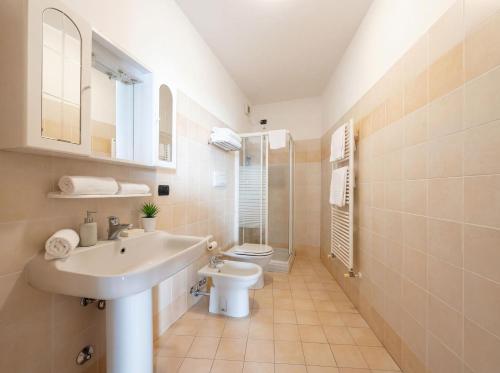 ein weißes Badezimmer mit Waschbecken und Toilette in der Unterkunft Central Duplex in Iseo - 2 Bedrooms - Private Parking & WiFi in Iseo