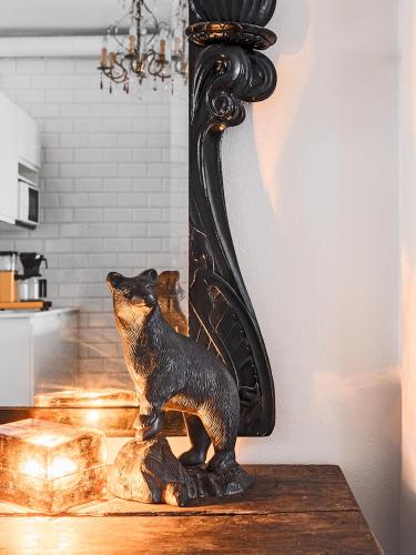 a statue of a bear on a table next to a mirror at Artist Apartment Susi in Helsinki