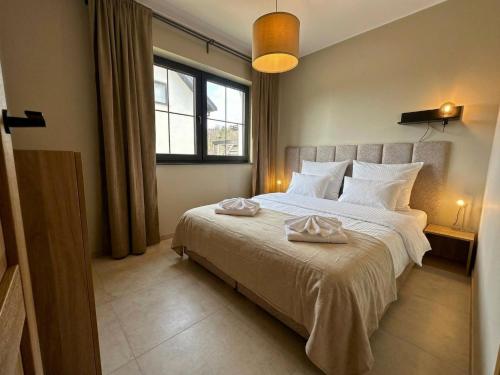 a bedroom with a bed with two towels on it at FORESTA in Redliny