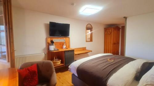 a bedroom with a bed and a tv on the wall at Gästehaus Holzer Kreuz - Gästezimmer Veilchen für 2 Personen inkl Landfrühstück in Fröhnd