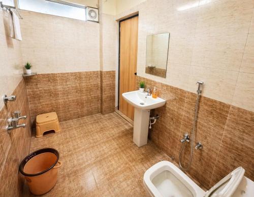 a bathroom with a sink and a toilet and a shower at Hotel Shreenath Heritage in Ujjain