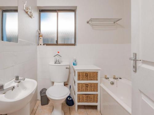 a bathroom with a toilet and a sink and a tub at Ocean View 147 in Struisbaai