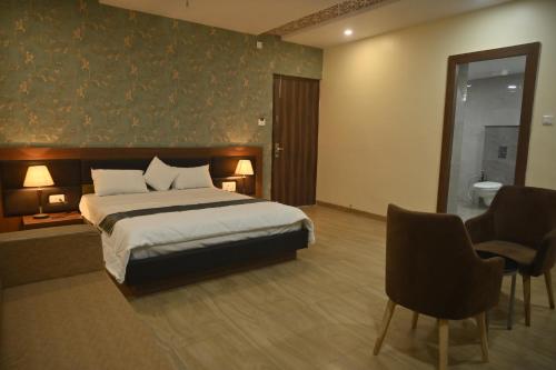 a hotel room with a bed and a bathroom at Hotel Vinayak International in Muzaffarpur