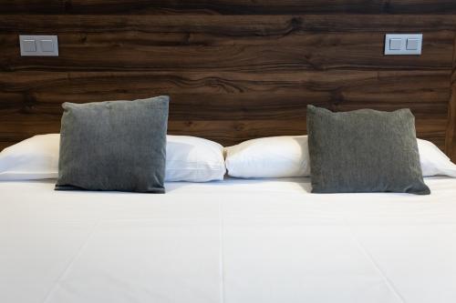 a white bed with two pillows on top of it at Alda Ruta Castilla in Palencia