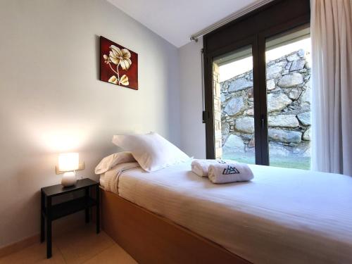 a bedroom with a large bed with a window at AC Apartaments Saüc Canillo in Canillo