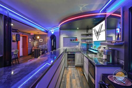 a kitchen with a bar with purple lighting at Event Lounge with Pool Table and Arcade in Lake Geneva