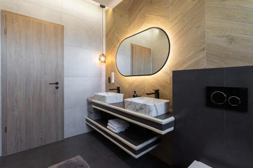 a bathroom with two sinks and a mirror at Villa Porta Verde IV - Infinity pool BBQ Luxury in Balatonalmádi
