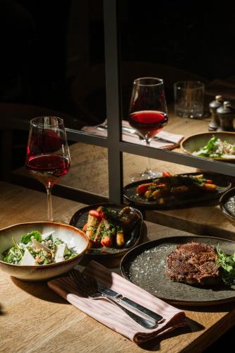 a table with plates of food and glasses of wine at Budapest Marriott Hotel in Budapest