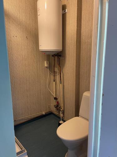 a small bathroom with a toilet and a tank at Gästis in Sollefteå