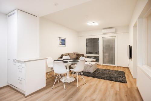 a white living room with a table and chairs at Lumi Apartments in Rovaniemi