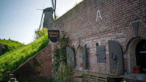 a brick building with a sign on the side of it at Siësta WouW in Woudrichem