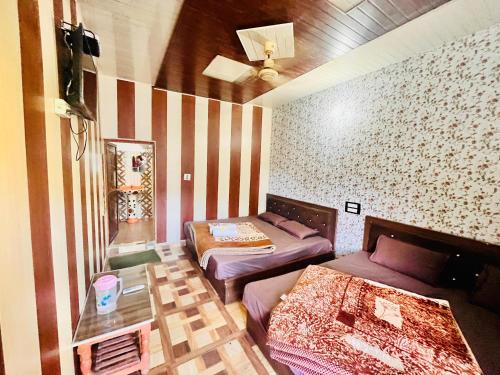 a room with two beds and a table at Hotel Dev in Kainūr