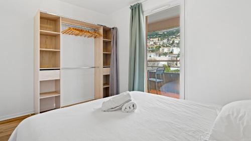 a white bedroom with a bed and a window at Virginia N302 - 2p4 in Grasse