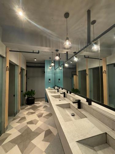 a row of sinks in a bathroom with mirrors at Maya Hostel El Nido in El Nido