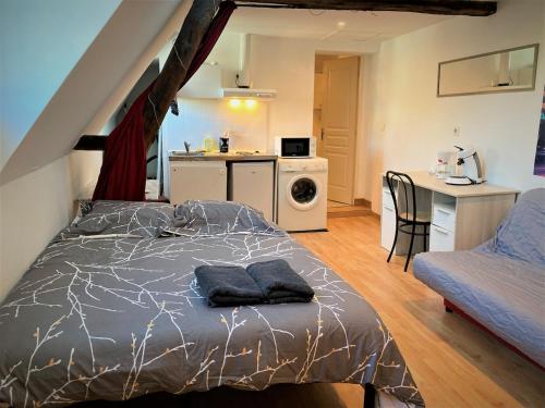 a bedroom with a bed and a kitchen with a table at Studio double dans l'hypercentre de Limoges in Limoges