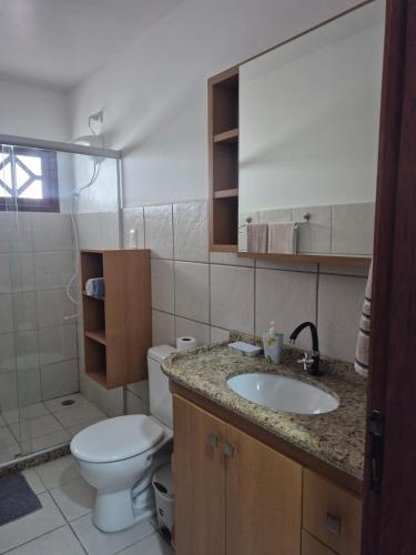a bathroom with a toilet and a sink at Casa Baraúnas 05 in Gravatá