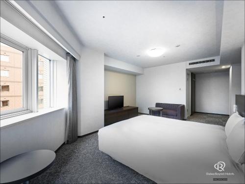a bedroom with a large white bed and a window at Daiwa Roynet Hotel Yokohama Kannai in Yokohama