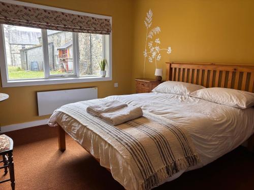 a bedroom with a bed with a blanket and a window at Kindrogan House in Straloch