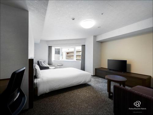 a hotel room with a bed and a television at Daiwa Roynet Hotel Yokohama Kannai in Yokohama