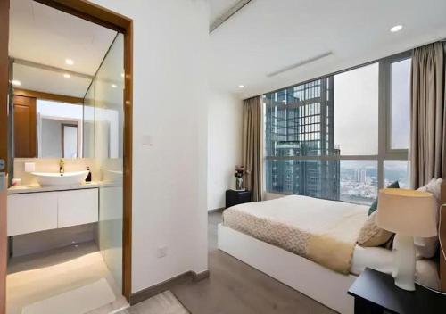 a bedroom with a large bed and a bathroom with a sink at Landmark City View - Apartment in Ho Chi Minh City