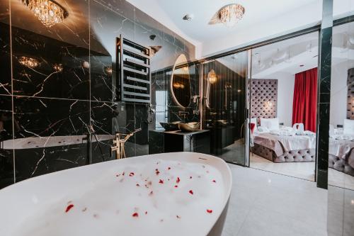 a bathroom with a bath tub and a bedroom at K52 Apartments in Wrocław