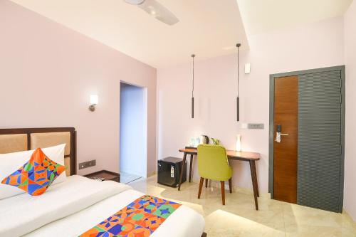 a bedroom with a bed and a table and a chair at FabHotel The White Cliff Inn - Near Max Hospital Saket in New Delhi